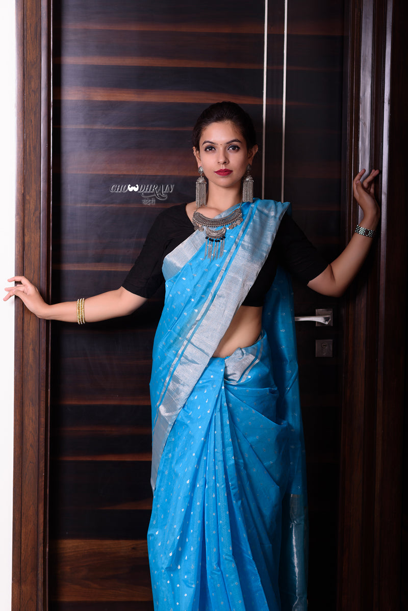 Blue silver chanderi sari is a handwoven Sari with silver zari water drop buttis all over the sari accompanied with a pallu with zari lines, along with a silver zari border spanning all the six yards. 